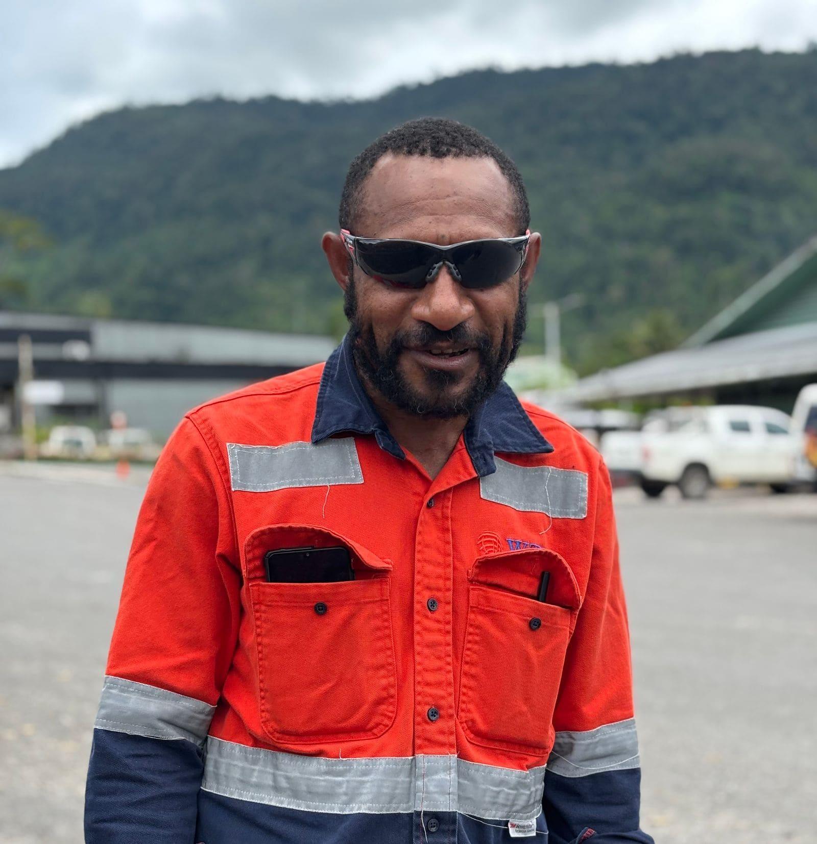 A tradesperson in orange hi-vis workwear on site