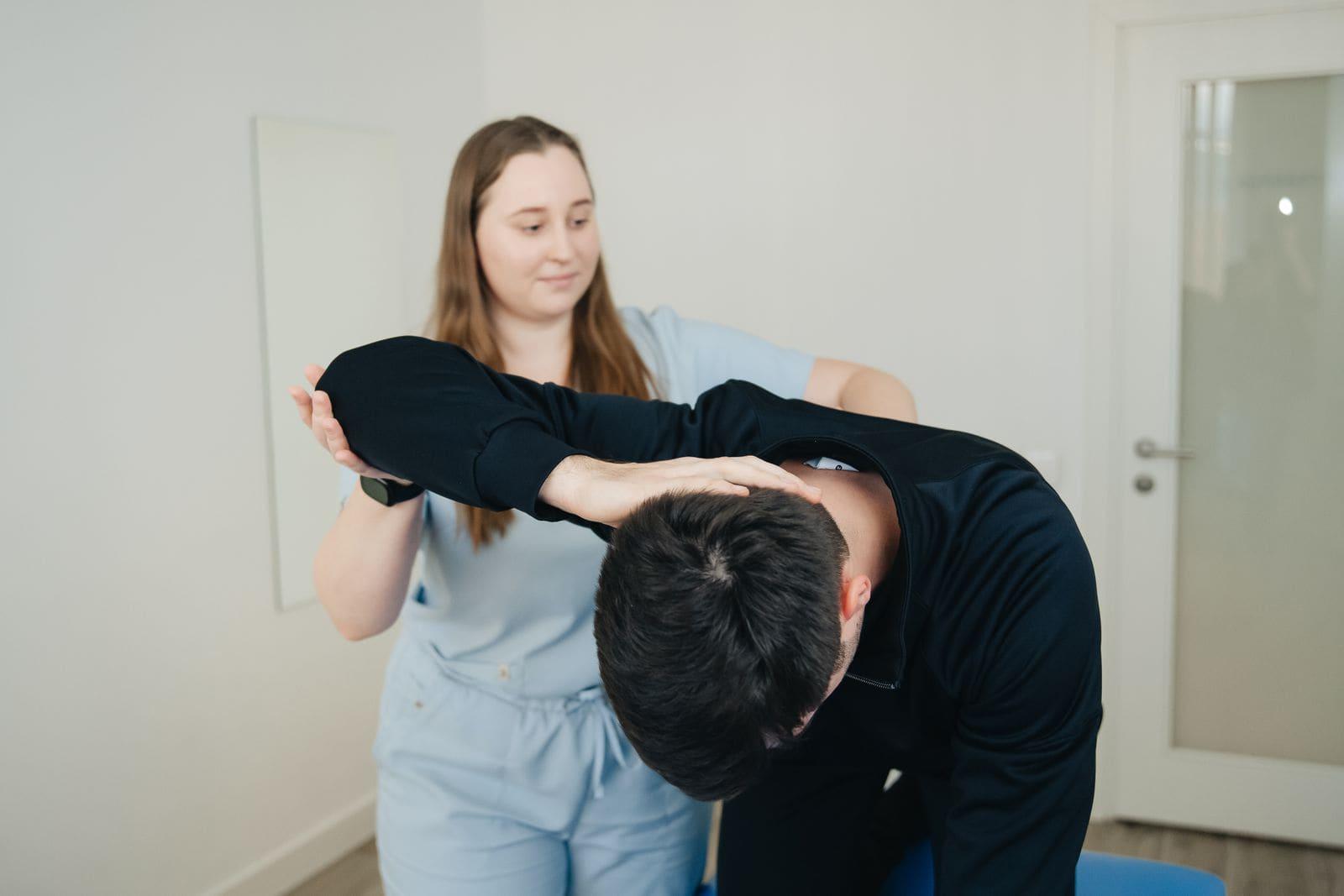 A physiotherapist guiding a patient through a back mobility movement